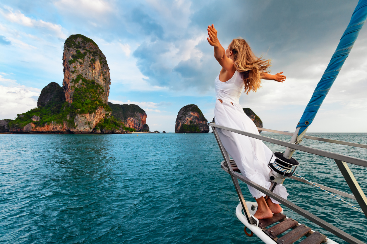 Happy girl on board of sailing yacht have a fun.