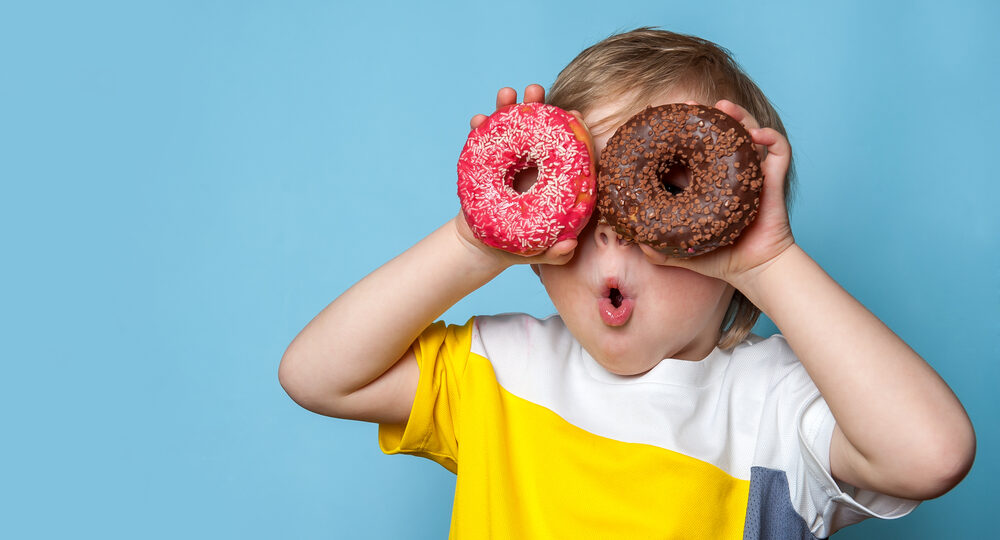 Little,Happy,Cute,Boy,Is,Eating,Donut,On,Blue,Background