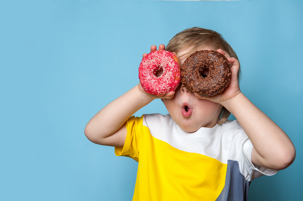 Little,Happy,Cute,Boy,Is,Eating,Donut,On,Blue,Background