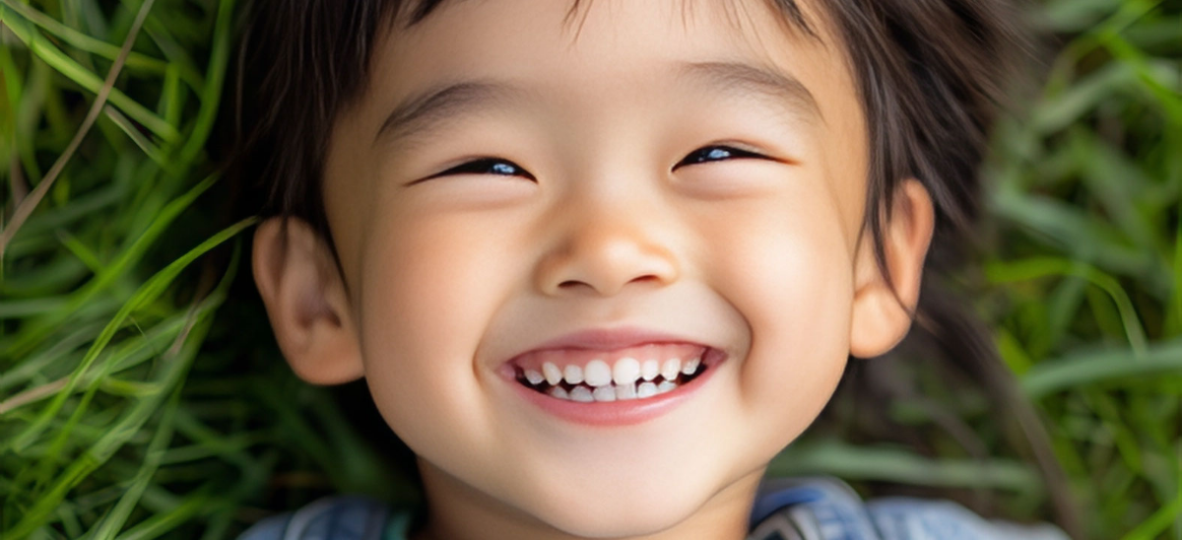 mediamice_smiling_Asian_child_laying_down_on_green_grass_54a3de12 dd88 412c b48d e5974057c1a8 topaz face upscale 4x