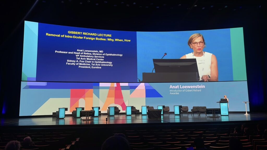 Prof. Anat Loewenstein on stage announcing the Gisbert Richard Lecture Award winner